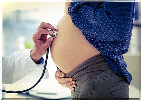 Doctor listening to the abdomen of a pregnant woman: premature birth